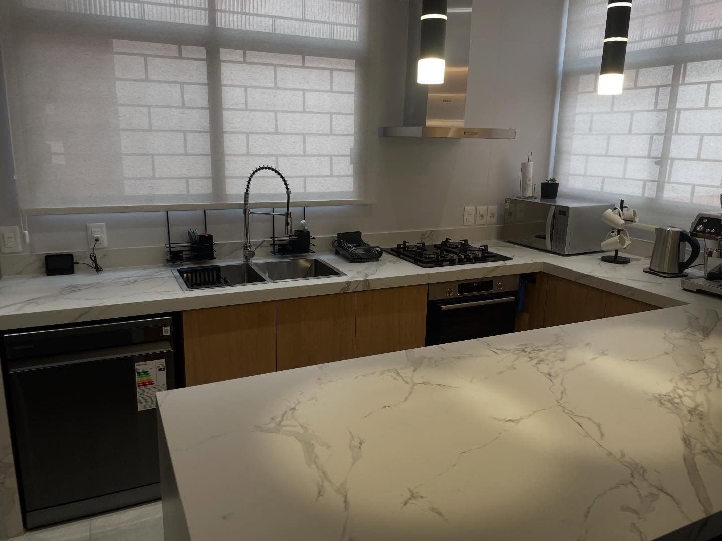 Cocina con isla y mesada en cascada en Dekton Aura — Montevideo · Nuevo Horizonte Marmolería