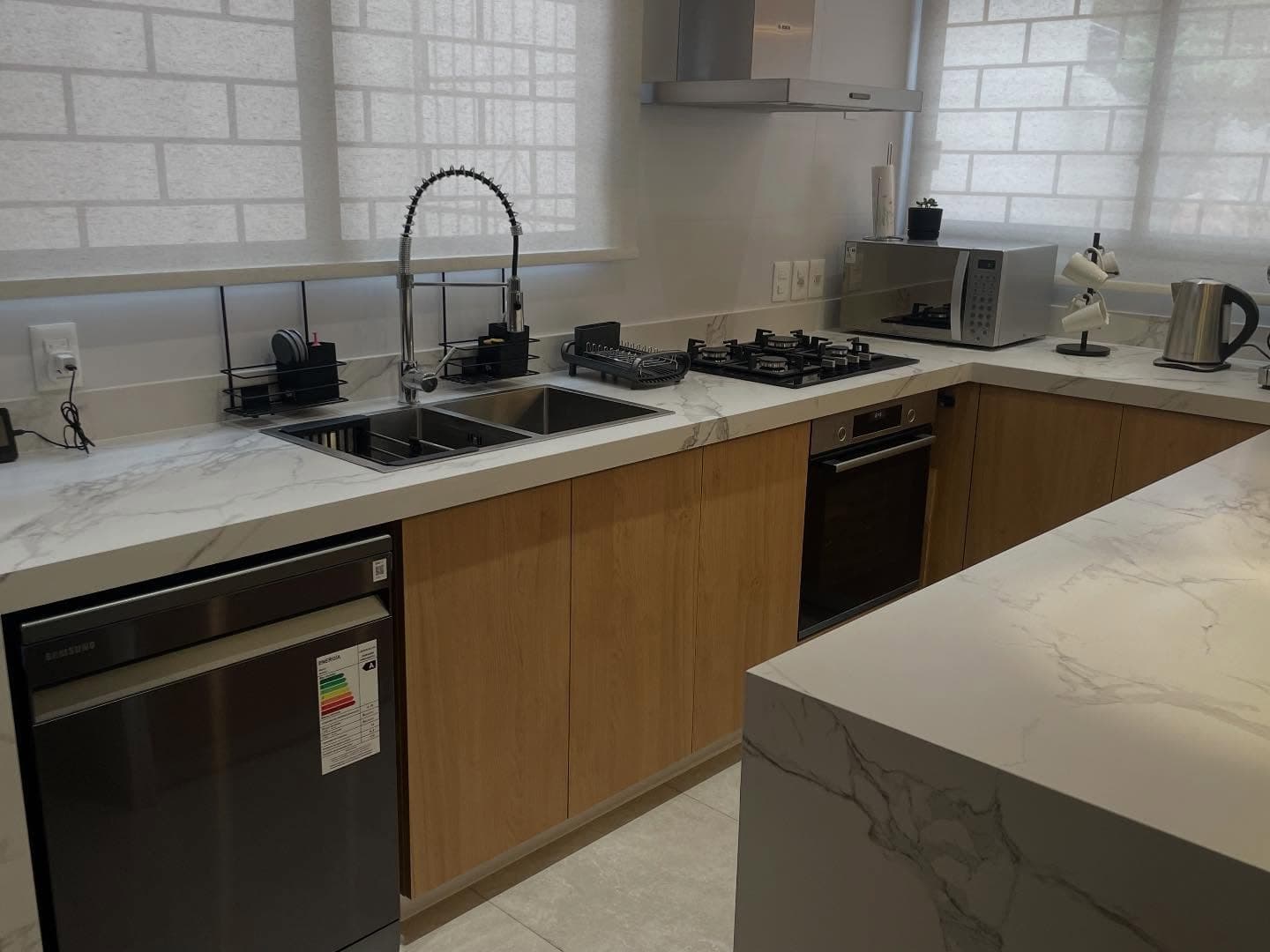 Cocina con isla y mesada en cascada en Dekton Aura — Montevideo · Nuevo Horizonte Marmolería