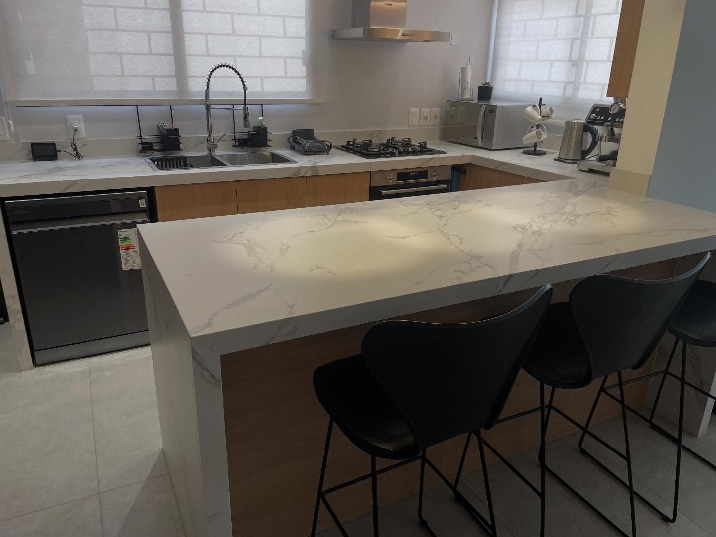 Cocina con isla y mesada en cascada en Dekton Aura — Montevideo · Nuevo Horizonte Marmolería