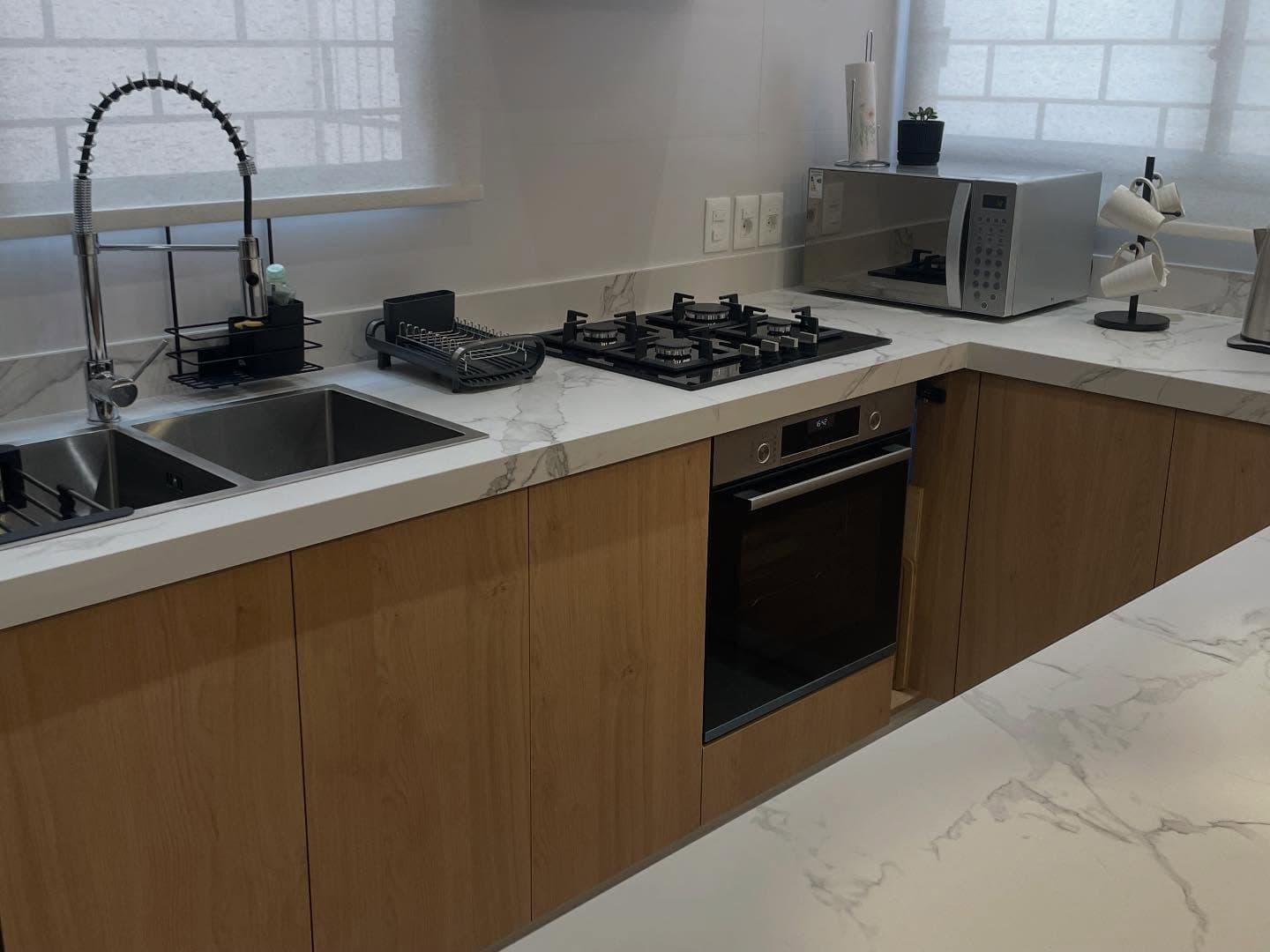 Cocina con isla y mesada en cascada en Dekton Aura — Montevideo · Nuevo Horizonte Marmolería